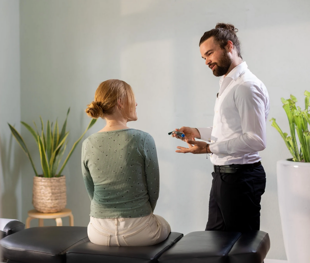 A patient discussing their sciatica pain with a chiropractor